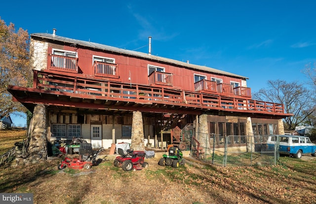 back of house featuring a wooden deck and stone siding