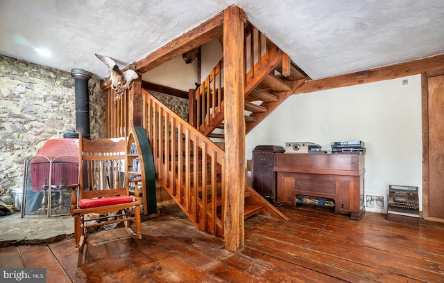 staircase with hardwood / wood-style flooring and a wood stove