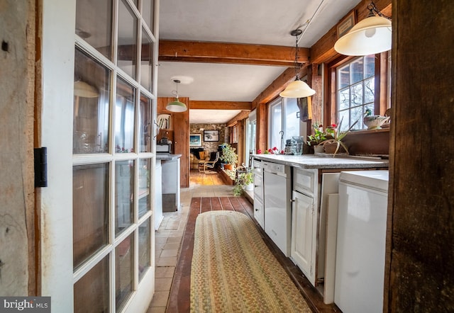 kitchen with beamed ceiling, decorative light fixtures, white cabinets, and refrigerator