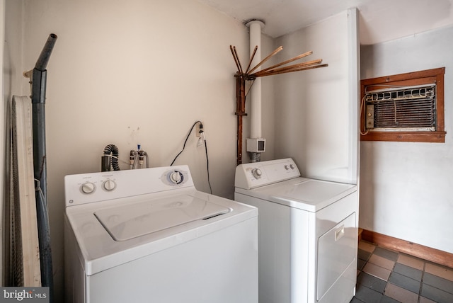 washroom with a wall mounted air conditioner and separate washer and dryer