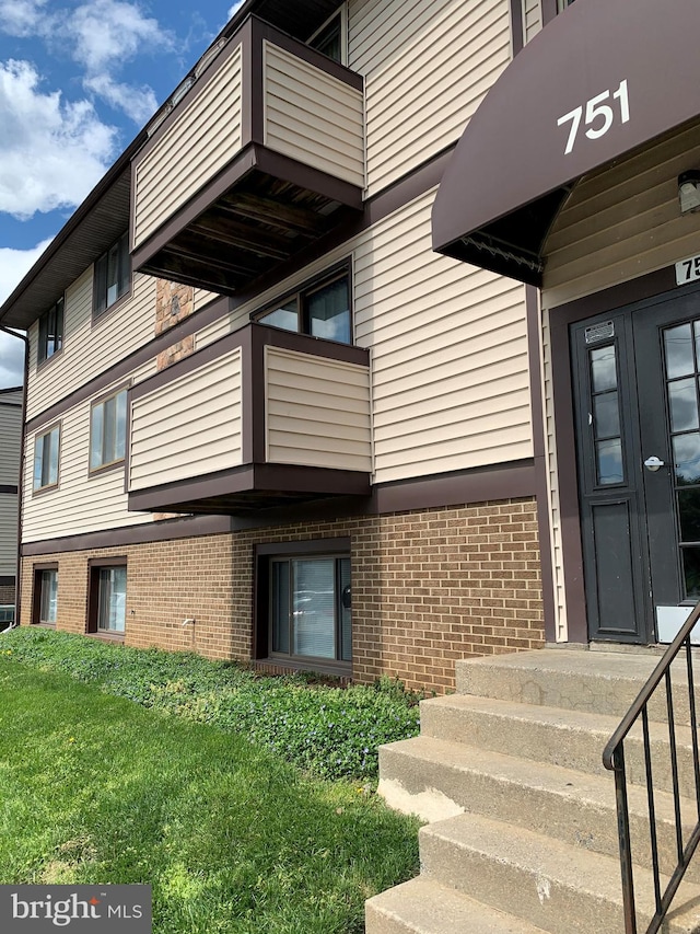 exterior space featuring a balcony and a yard