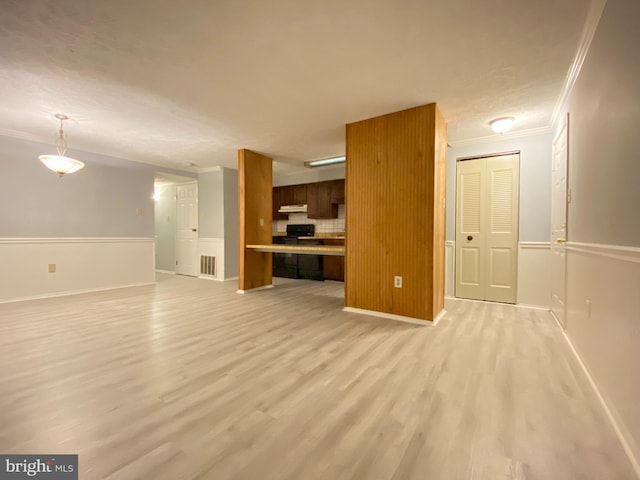 unfurnished living room featuring ornamental molding and light hardwood / wood-style flooring