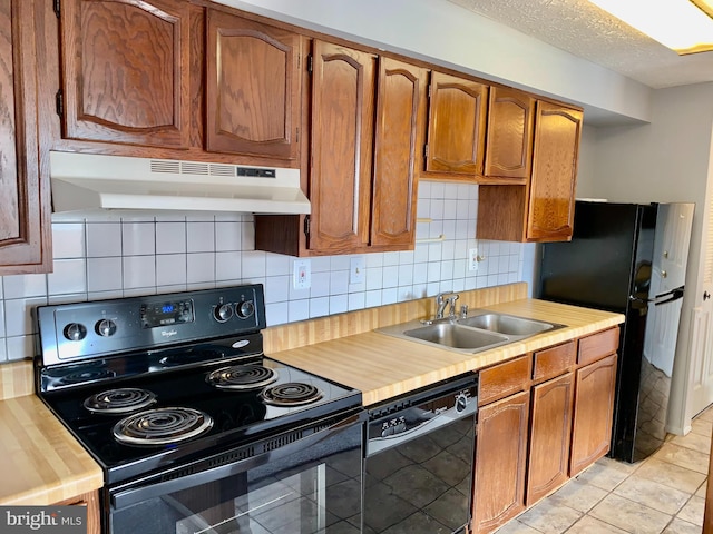 kitchen featuring light tile patterned floors, sink, black appliances, and tasteful backsplash