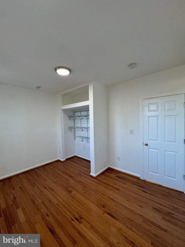 unfurnished bedroom featuring a closet and dark hardwood / wood-style floors