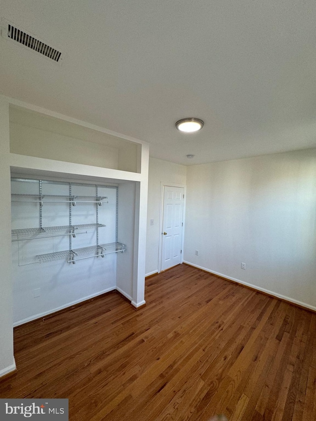 unfurnished bedroom with a closet and dark wood-type flooring