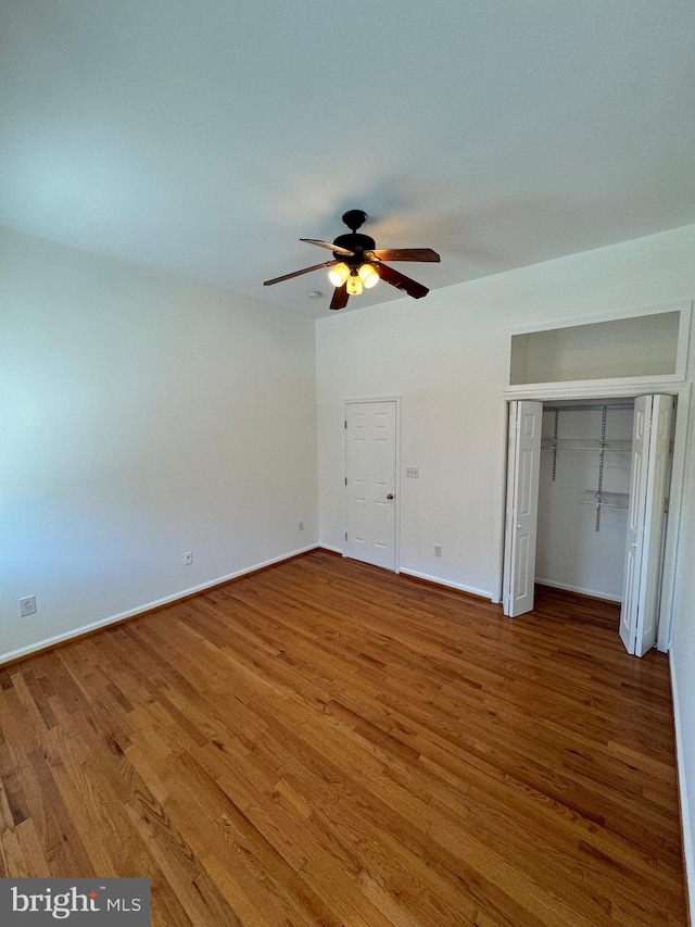 unfurnished bedroom with ceiling fan, a closet, and wood-type flooring