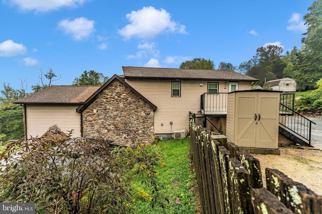 back of property featuring a storage shed