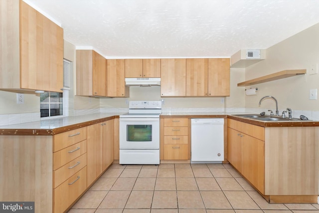 kitchen with white appliances, sink, light tile patterned floors, a textured ceiling, and light brown cabinetry