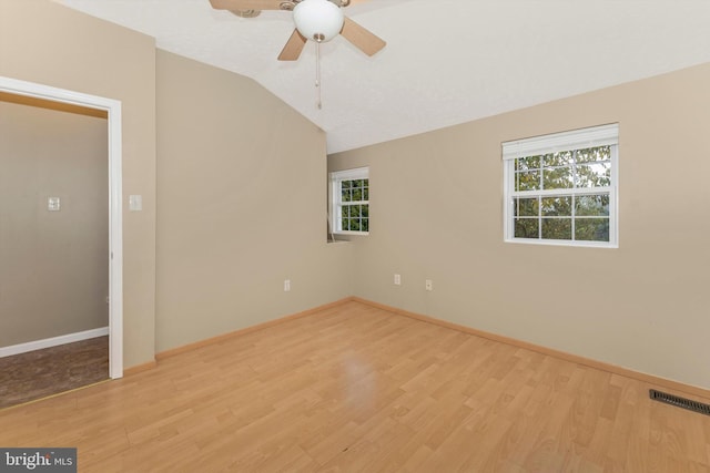 unfurnished room featuring ceiling fan, vaulted ceiling, and light wood-type flooring