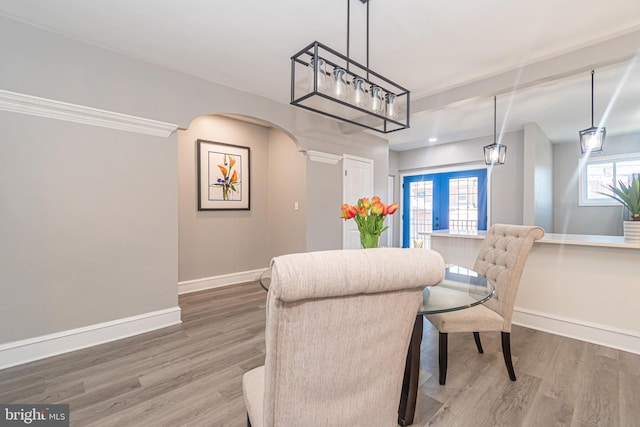 dining area with french doors, wood-type flooring, and a healthy amount of sunlight