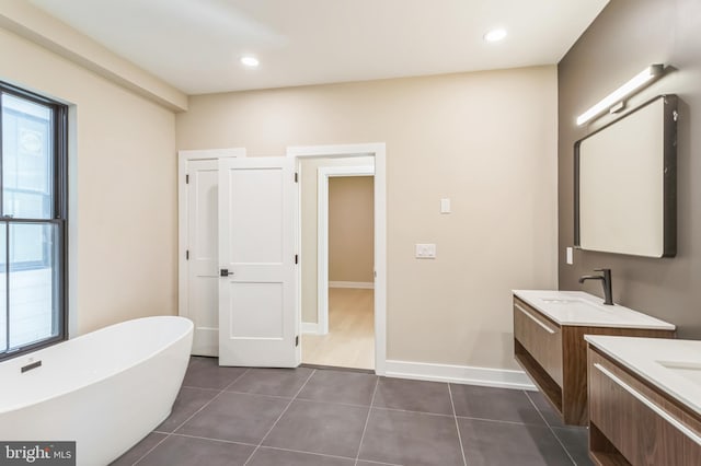 bathroom featuring tile patterned floors, vanity, and a bath