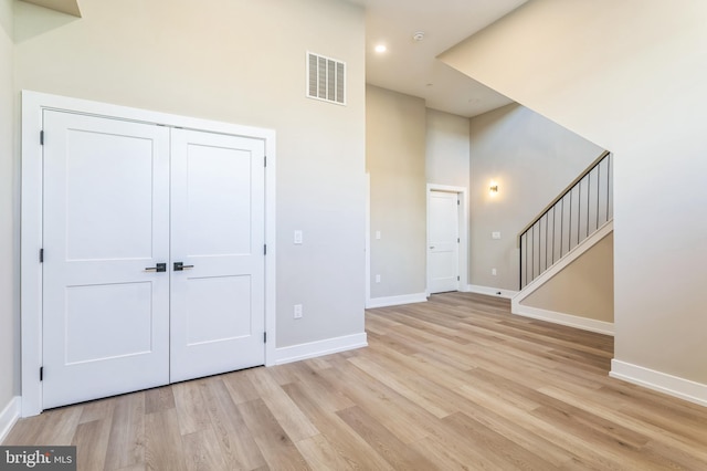 entryway with a towering ceiling and light hardwood / wood-style floors