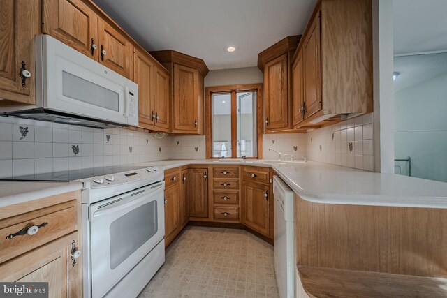 kitchen with kitchen peninsula, tasteful backsplash, and white appliances