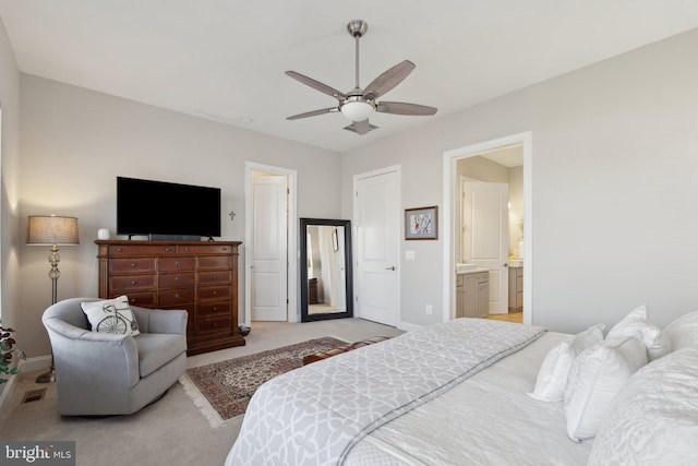 bedroom featuring ceiling fan, light carpet, and ensuite bath