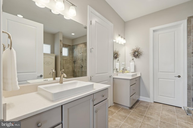 bathroom with tile patterned flooring, vanity, and a tile shower