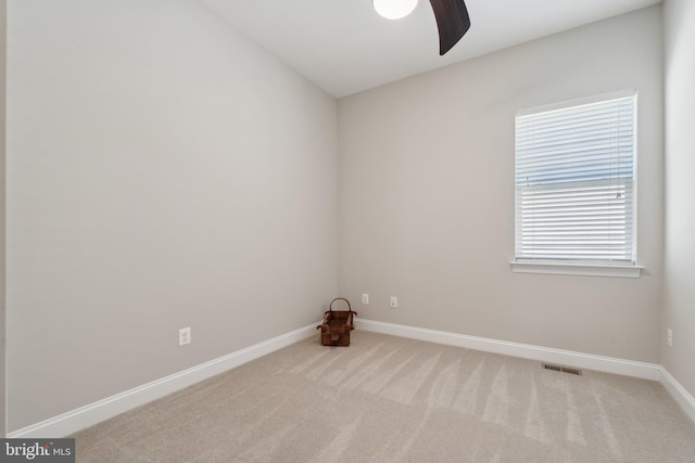 empty room with ceiling fan and light colored carpet