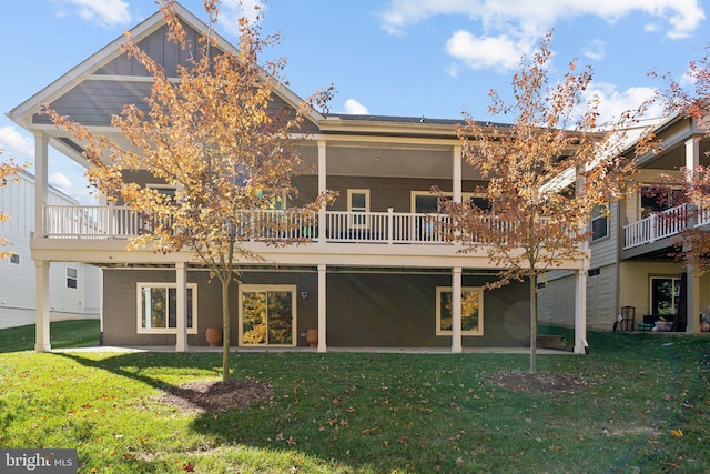 rear view of house featuring a wooden deck and a yard