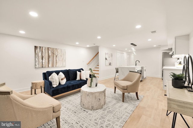 living room with light wood-type flooring and sink