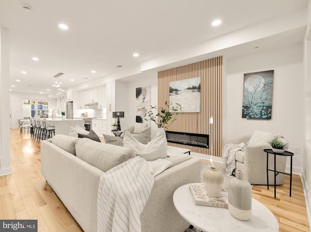 living room with light hardwood / wood-style floors and sink