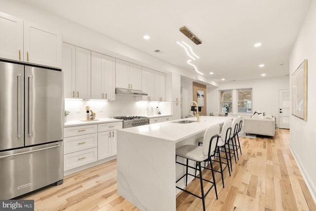 kitchen with light wood-type flooring, white cabinetry, and stainless steel appliances