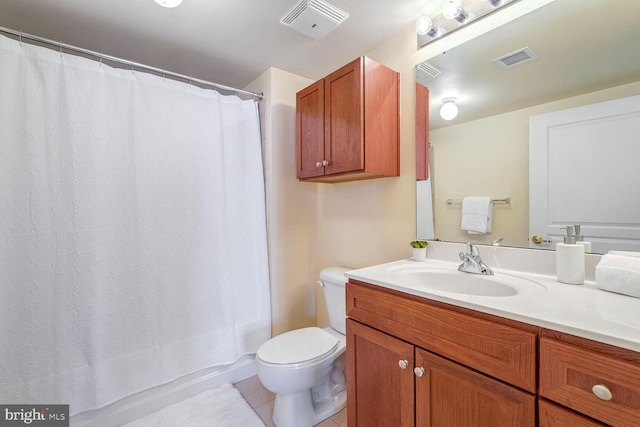 bathroom with tile patterned flooring, vanity, and toilet