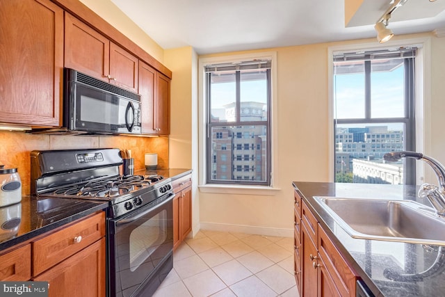 kitchen featuring black appliances, tasteful backsplash, sink, and track lighting