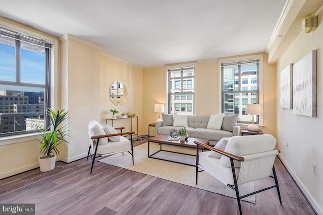 living room with wood-type flooring, ornamental molding, and plenty of natural light