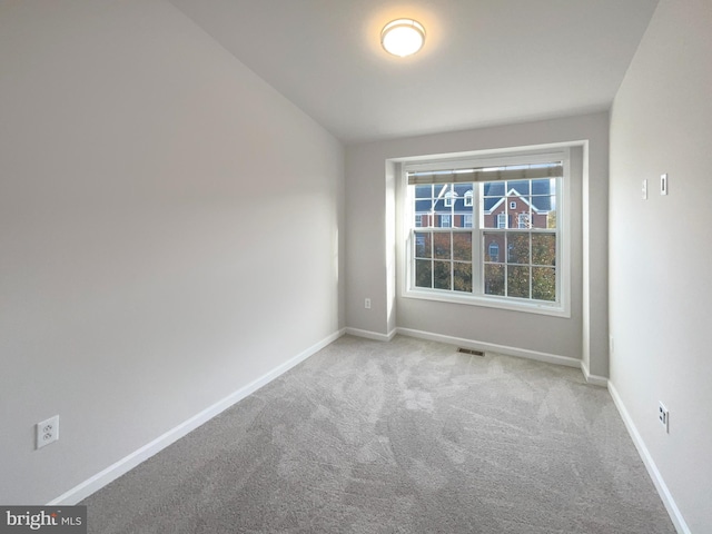 empty room with lofted ceiling and light colored carpet