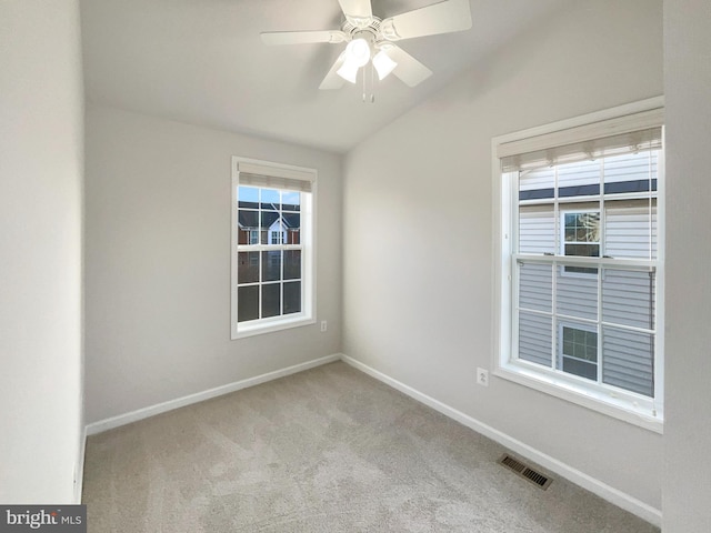 empty room featuring ceiling fan, light colored carpet, and vaulted ceiling