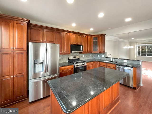 kitchen with stainless steel appliances, dark hardwood / wood-style flooring, hanging light fixtures, sink, and a kitchen island