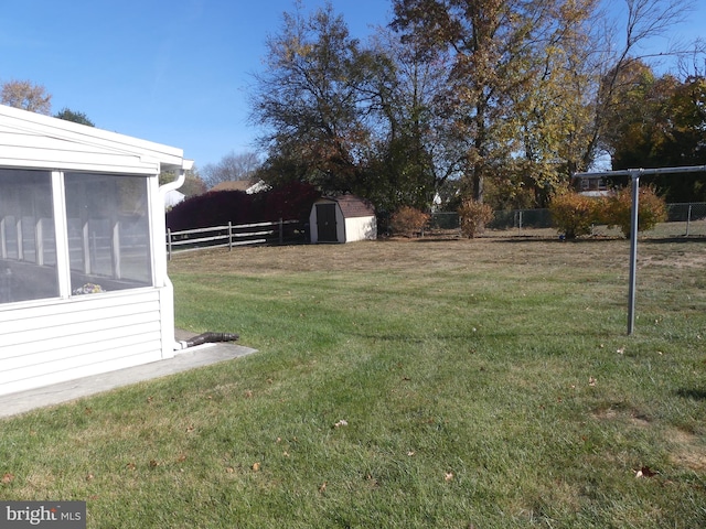 view of yard with a sunroom and a storage unit