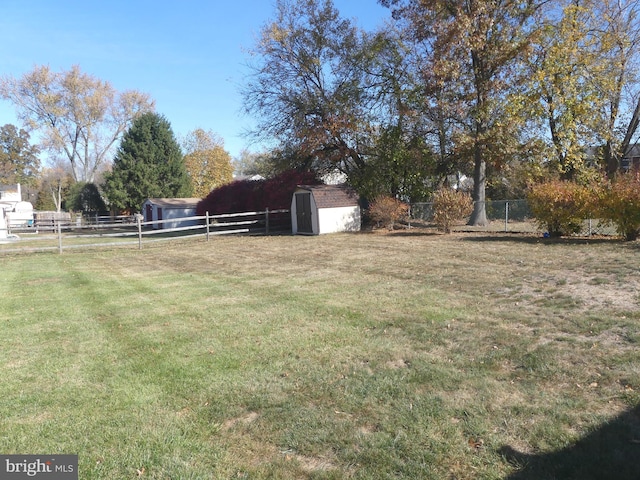 view of yard with a rural view and a storage shed