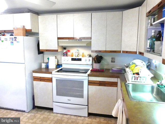 kitchen featuring white cabinets, white appliances, and sink