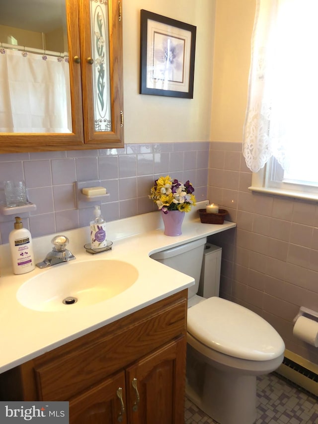 bathroom featuring tile walls, a baseboard radiator, vanity, and toilet