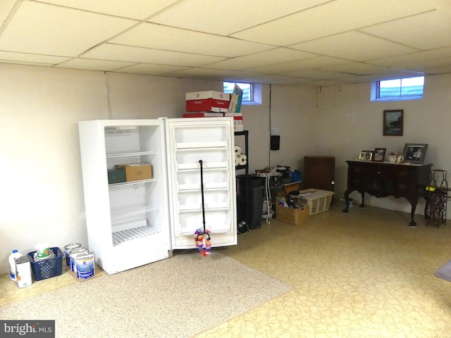 basement with a drop ceiling and plenty of natural light