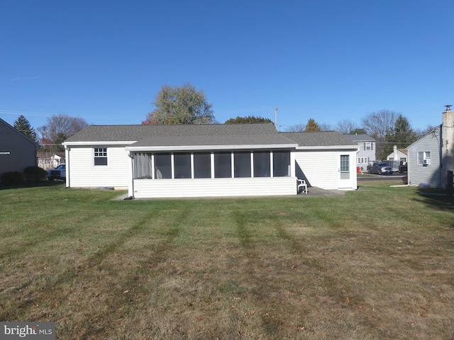 rear view of property with a sunroom and a yard