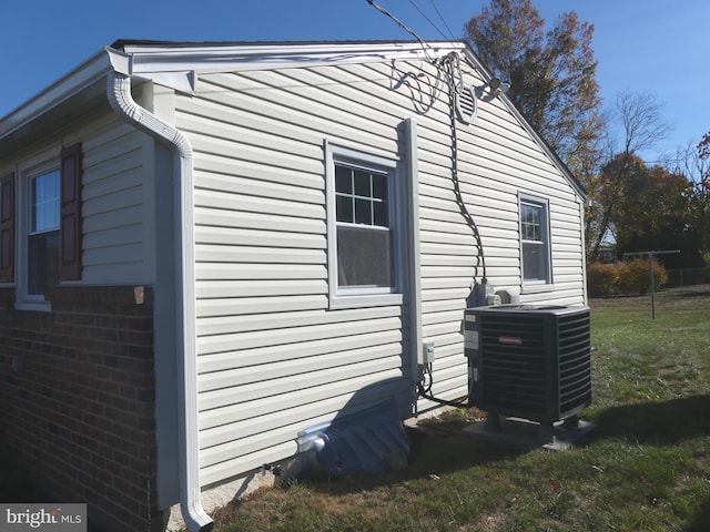 view of side of property with cooling unit and a yard