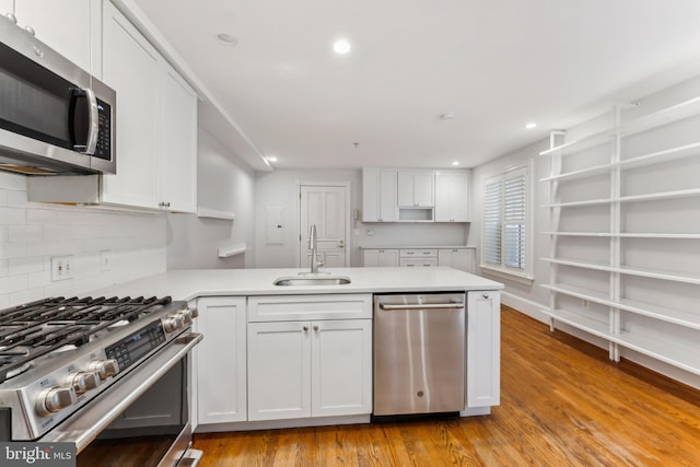 kitchen featuring white cabinetry, kitchen peninsula, sink, and stainless steel appliances