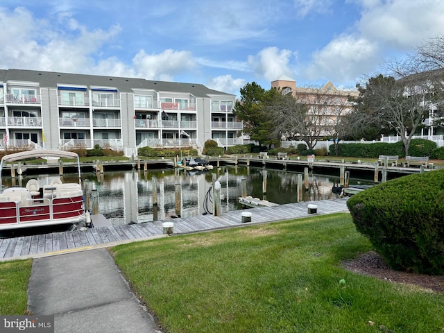 dock area with a water view and a lawn