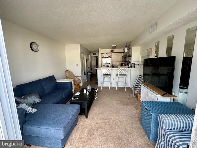 living area featuring light carpet, visible vents, and a textured ceiling