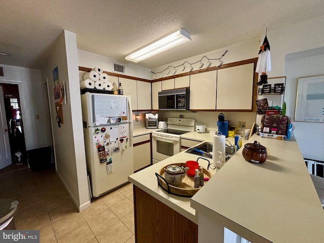 kitchen featuring light tile patterned floors, visible vents, light countertops, white appliances, and a peninsula