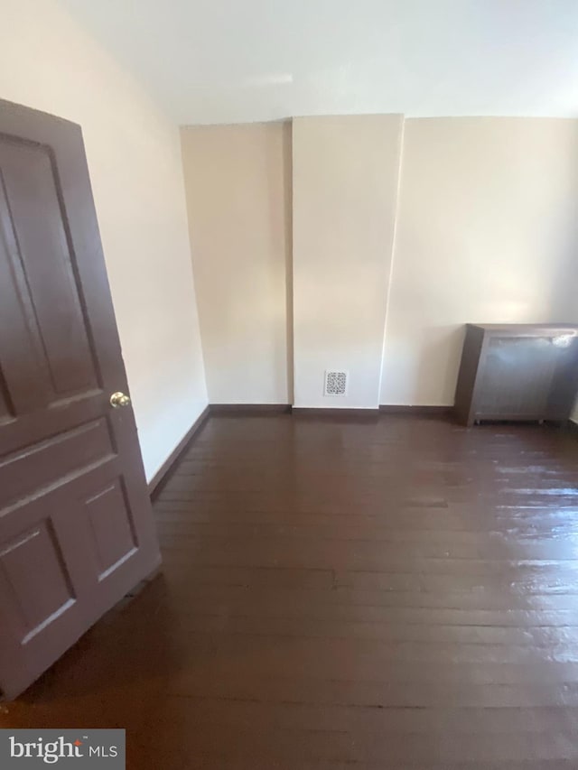 empty room featuring dark hardwood / wood-style flooring