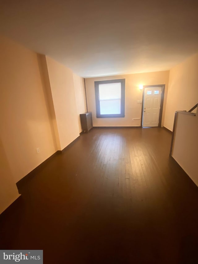 spare room featuring radiator heating unit and dark hardwood / wood-style flooring