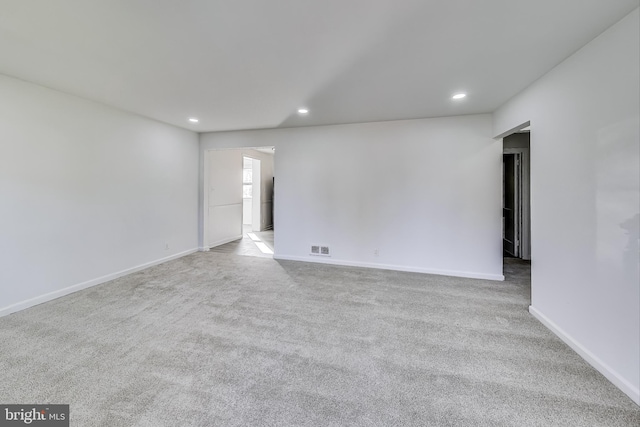 spare room featuring light carpet