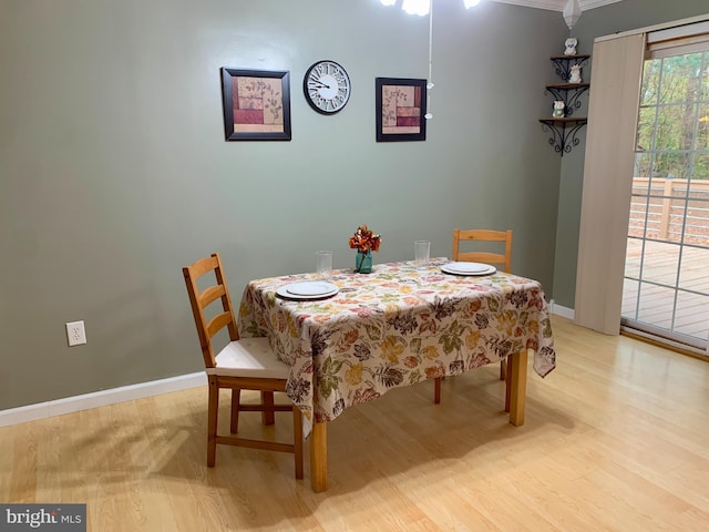 dining room featuring ornamental molding and light hardwood / wood-style flooring