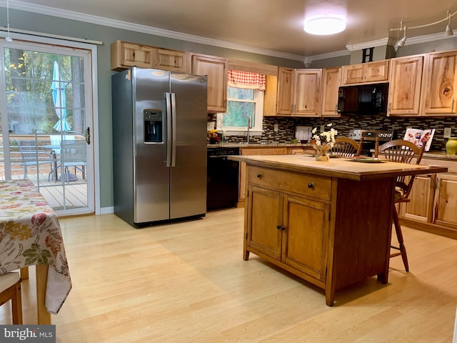 kitchen featuring black appliances, a kitchen island, ornamental molding, tasteful backsplash, and light hardwood / wood-style floors