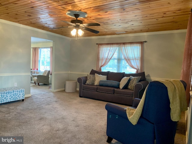 living area featuring ceiling fan, carpet floors, wooden ceiling, and crown molding