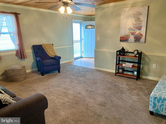 sitting room featuring wainscoting, crown molding, and carpet flooring