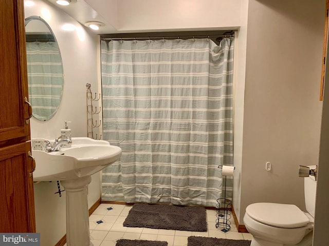 bathroom featuring curtained shower, tile patterned flooring, and toilet