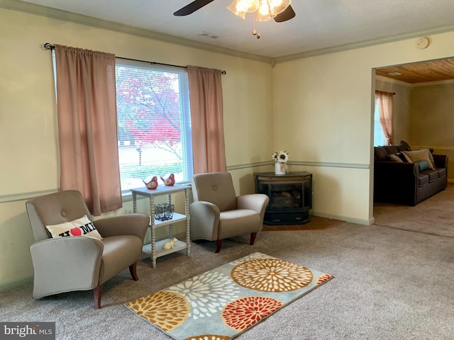 living area featuring carpet floors, a wood stove, ceiling fan, and ornamental molding